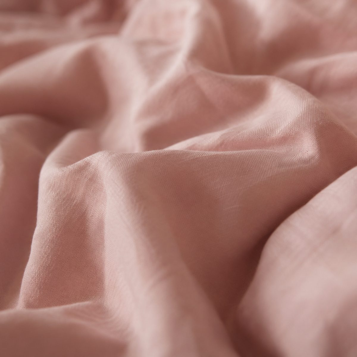 Gros plan sur un drap froissé aux tons rosés